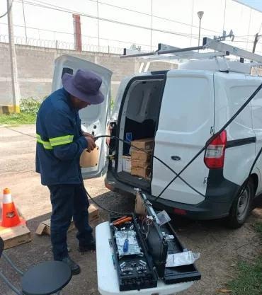 Camión grúa con brazo articulado rojo en calle